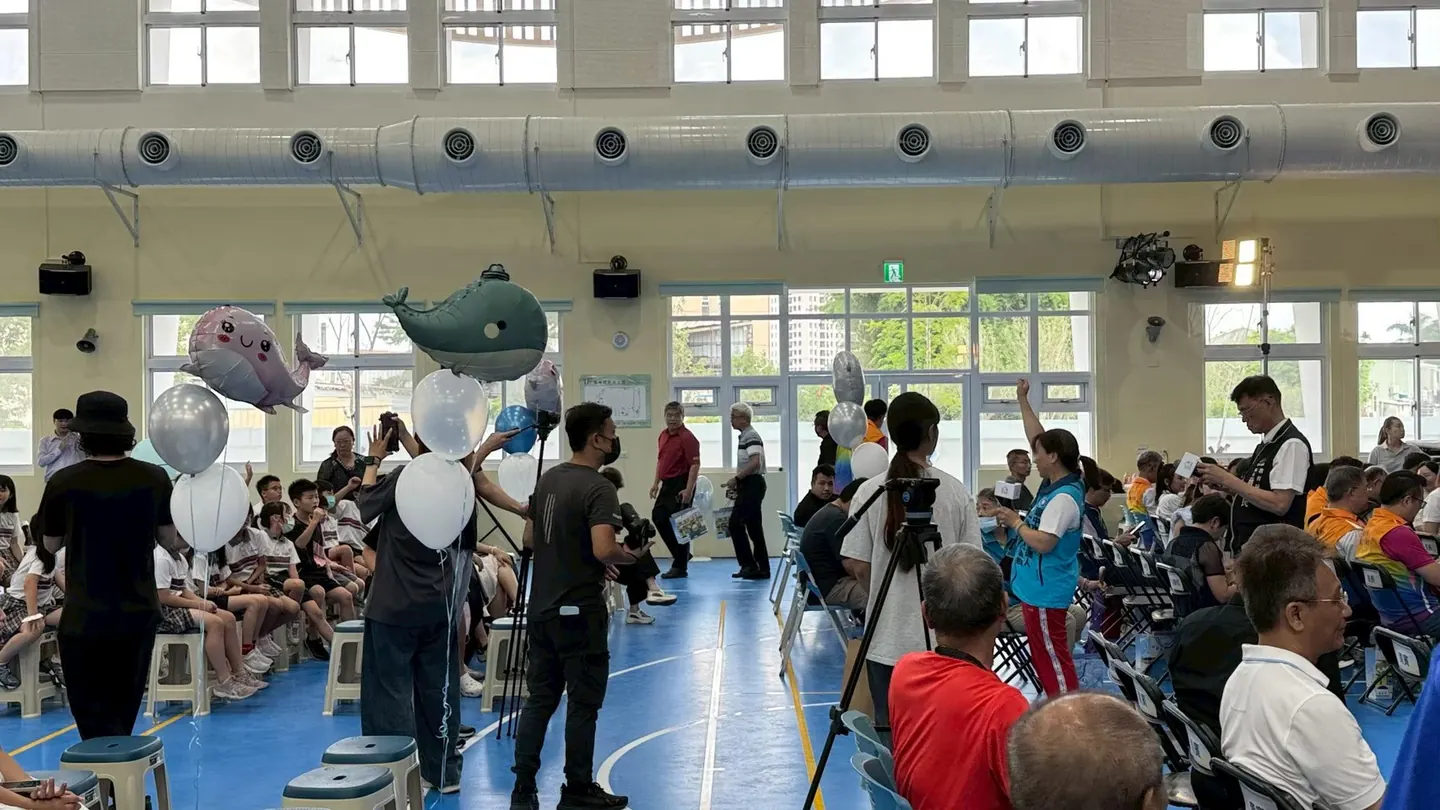 來賓與學生帶著鯨魚氣球進入會場