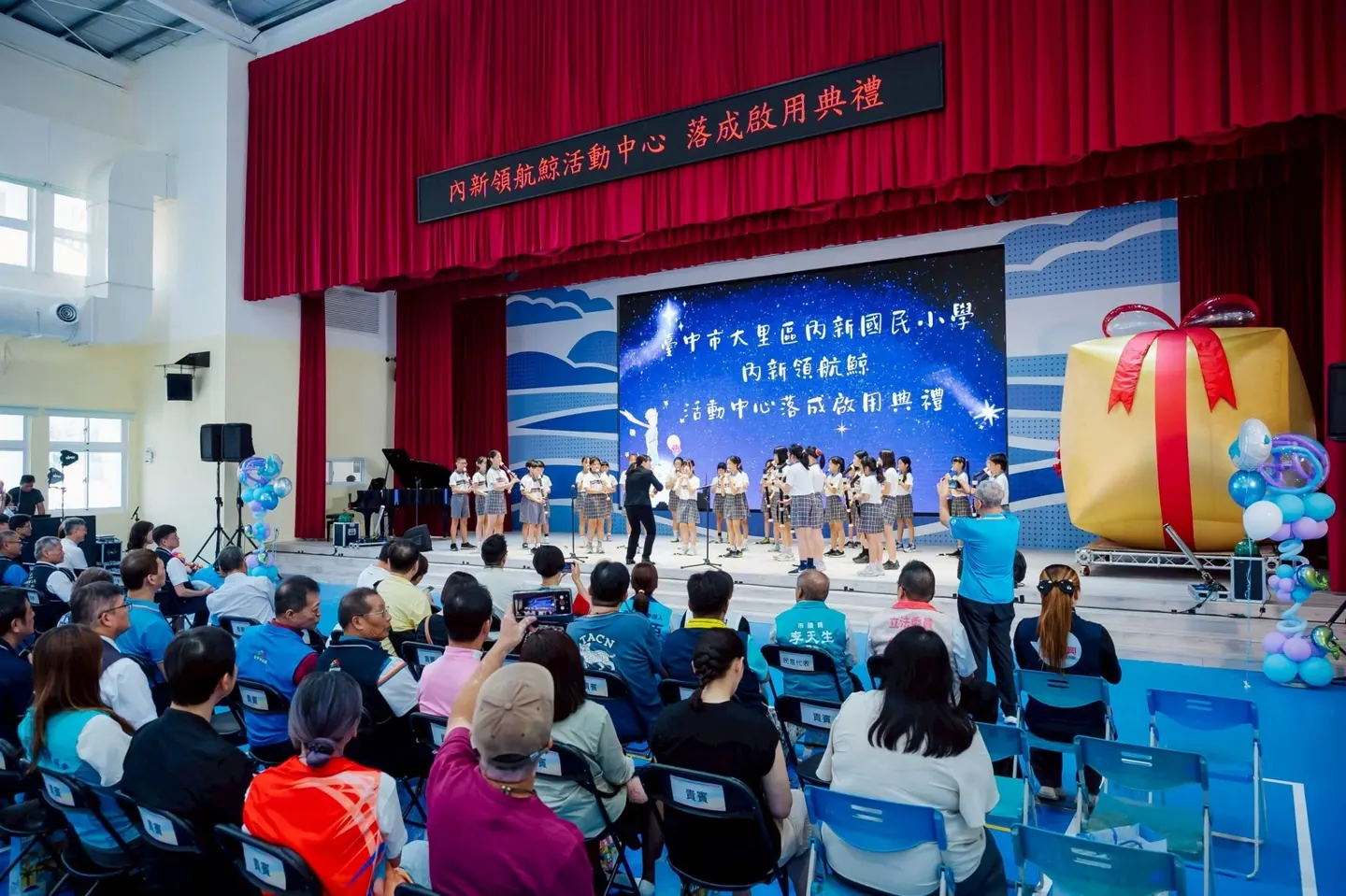 典禮開始，學生在舞臺上演出，臺下坐滿家長與來賓