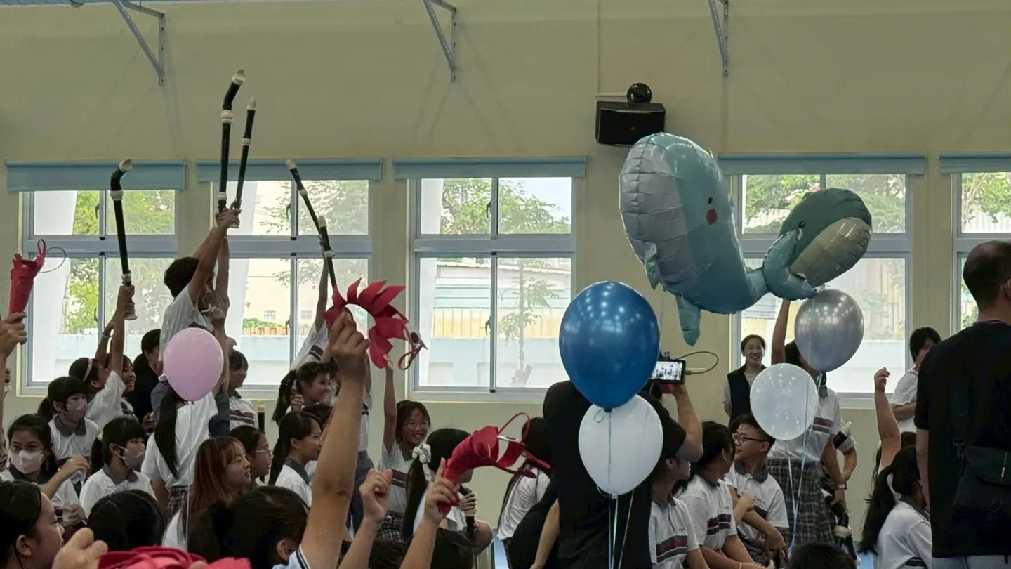 學生高舉鯨魚氣球一起慶祝