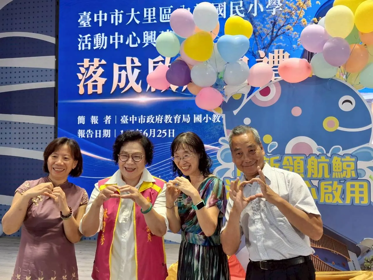來賓在鯨魚看板前比愛心