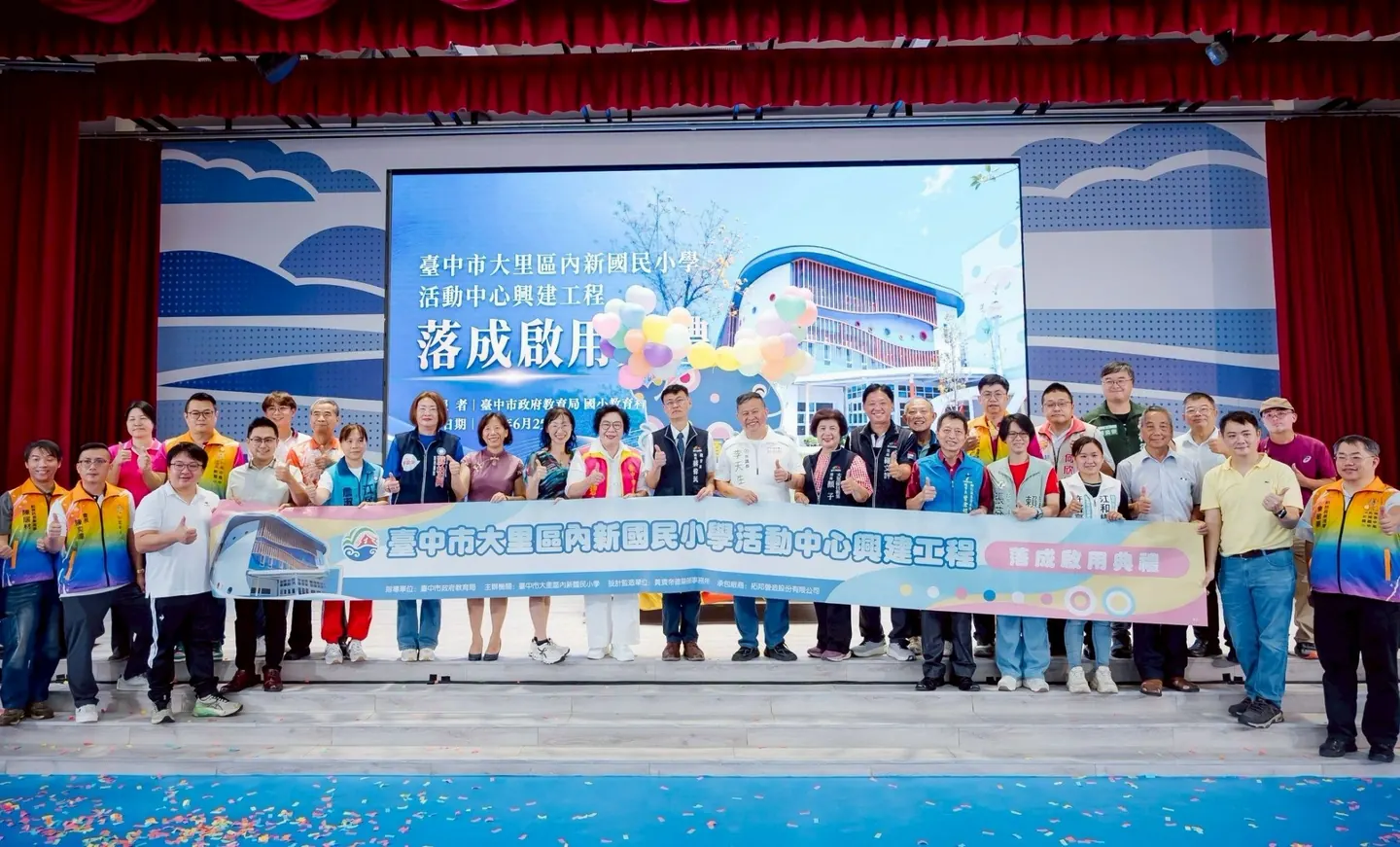 來賓拉著活動中心興建工程布條在舞臺上合影